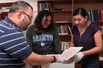 Professor and students looking at archived documents