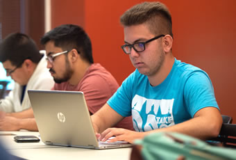 Male on computer in class